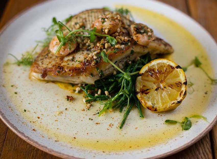 Fish with burnt lemon on a plate