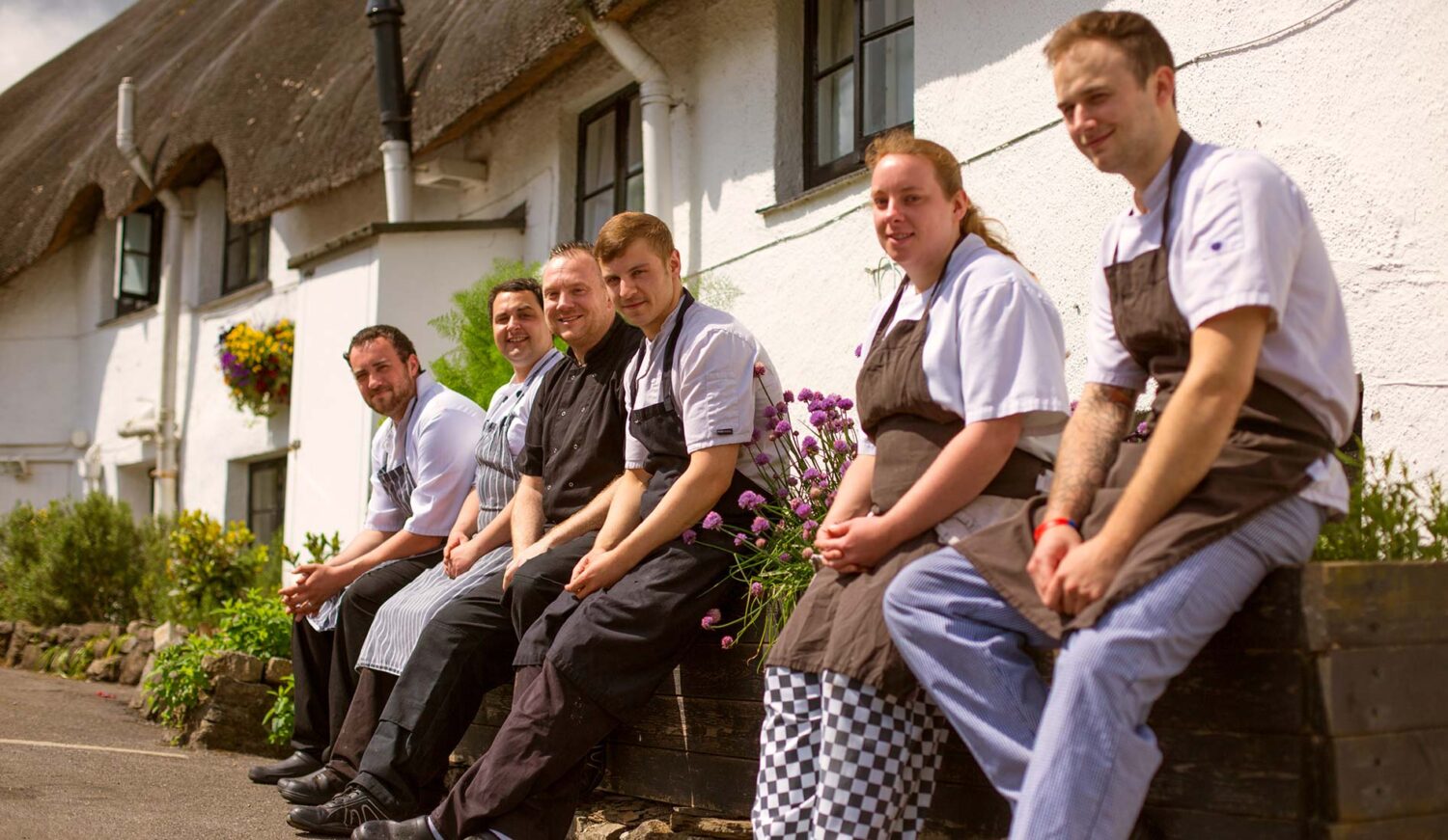 Cott Inn Pub Kitchen Staff sitting on a wall